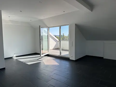 Heller Wohnraum unter dem Dach mit Tür zur Dachterrasse