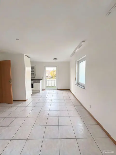 Leeres Wohnzimmer im Obergeschoss mit Tür zum Balkon, mit KI bearbeitet